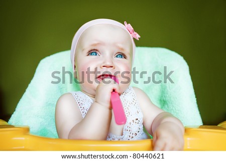 crying child with spoon in mouth