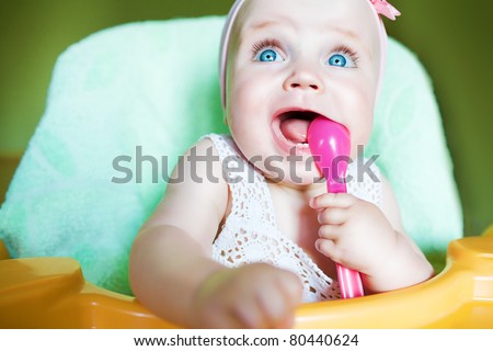 little child with pink spoon in mouth - stock photo