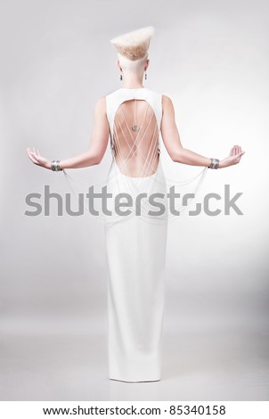 blond woman in white dress with creative hairstyle from back