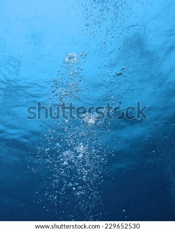 Abstract underwater scene sunrays and air bubbles in deep blue sea