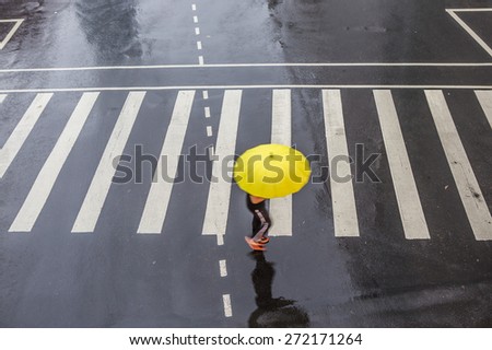 People walking on big city street, blurred motion zebra crossing abstract in the rain.
