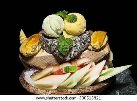 Assorted ice cream with banana, wax apple mint, apple and water melon in the wooden bowl.