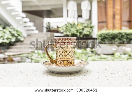 Antique style coffee cup as zen garden background.