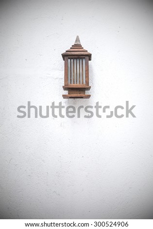 Vintage wooden bracket light on the rough wall of the building