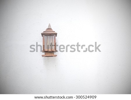 Vintage wooden bracket light on the rough wall of the building