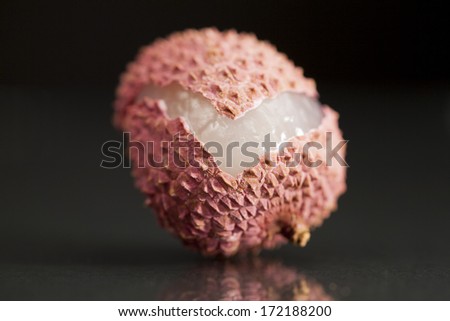 Litchi fruit, partial peeled with black background
