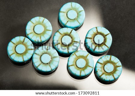 Turquoise flower shaped gems with black and white background