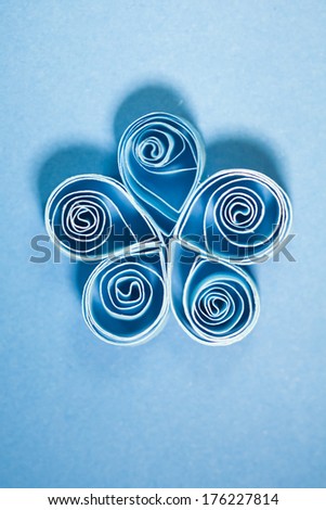 Quilling flower from blue paper on blue paper background
