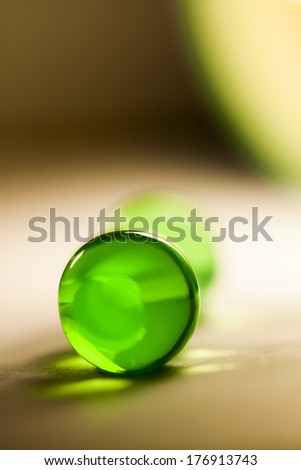 Abstract composition with beautiful, green, round jelly balls, paper surface and paper background - extreme closeup with soft focus