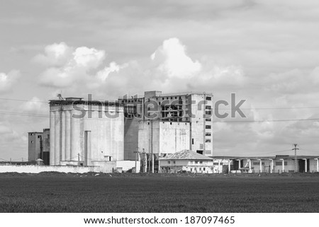 Black and white abandoned industrial building with beautiful sky and clouds
