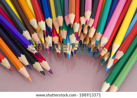 Group of sharp colored pencils with white and red background and reflexions