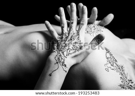 Henna tattoo on parts of a woman body with black background