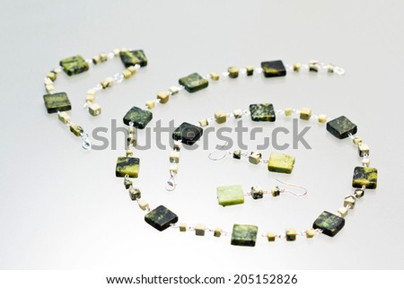 Silver jewels with colorful precious stones and light grey background