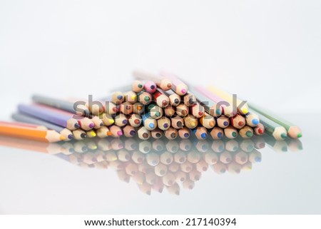 Group of sharp colored pencils with white background and reflexions