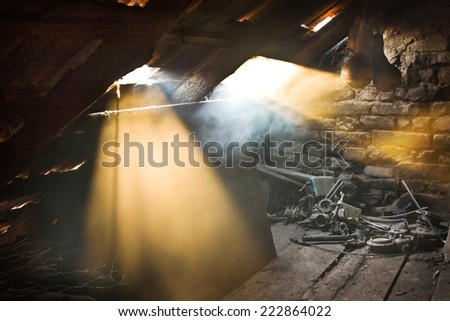 Glass, wooden and metallic objects in the attic with dust and spiderwebs in a beautiful, moody light