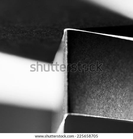 Blurred dark paper shapes and shadows with black paper background
