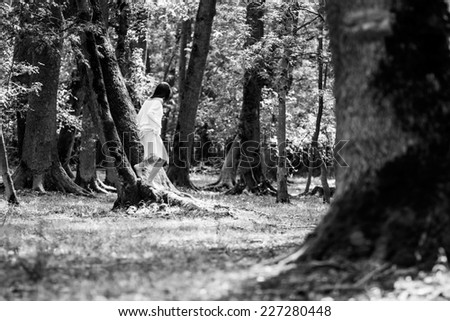 Brunette woman posing in the forest with beautiful light. Black and white photography