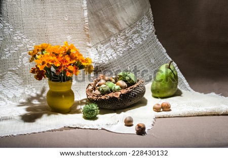 Still life composition with orange flowers and fruits. Image has grain texture visible on maximum size