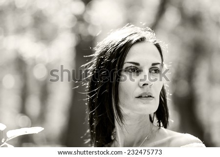 Brunette woman posing in the forest with beautiful light. Black and white photography
