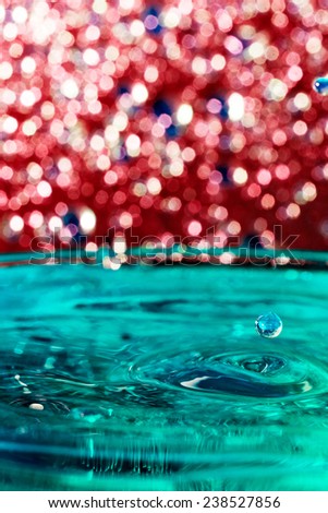 Abstract, colorful composition with small bokeh lights, water drops and water texture. Can be used as Christmas background
