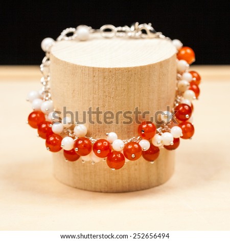 Silver jewels with colorful precious stones and wooden background