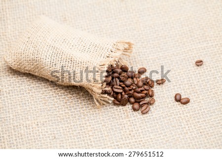 Coffee beans and small bag with burlap texture