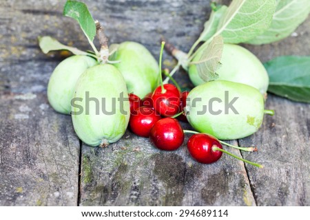 Green, summer apples and cherries with old wood texture