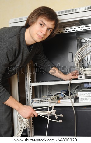 System administrator with wires in hand near server