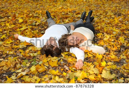 Boyfriend and girlfriend lying on the leaves in park
