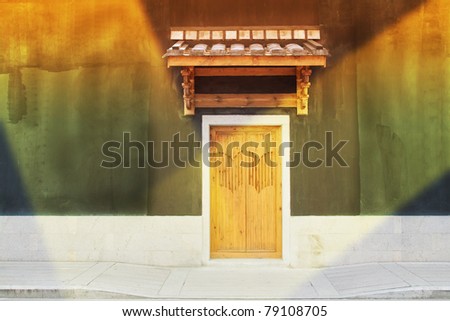 An old chinese  door  in a illuminating wall