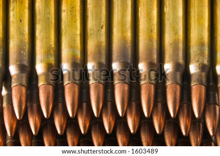 5.56mm bullets in stripper clips stacked. Tips pointed toward viewer. Brass casings are visible, as is discoloration at case necks caused by annealing which prevents case head separation. Closeup.