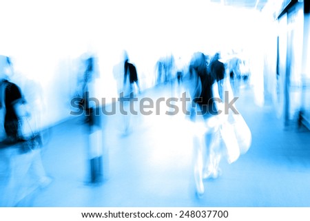 Group of people in motion blur walking in metro station.