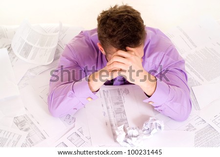 Handsome Caucasian man very emotional in the papers on a light background