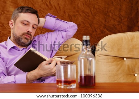 nice guy drinking whiskey and reading at table