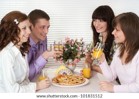 Nice Caucasian charming company of four people sit and eat pizza at a cafe