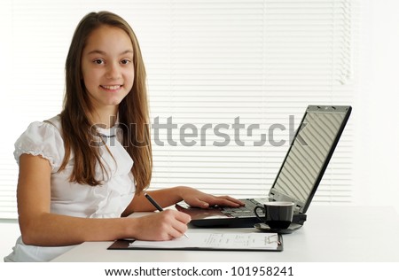 nice girl at the laptop sits on a white