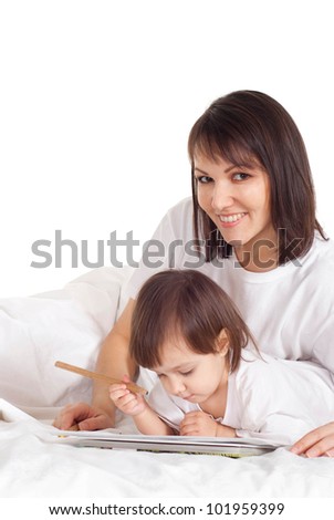 A mum with her daughter lying on the bed with a pencil