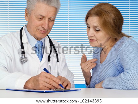 Caucasian nice old doctor with a patient on a light background