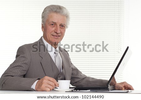 an elderly man sitting at the computer on a background