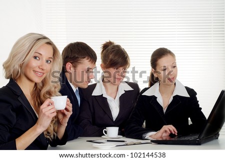 The company of four beautiful  caucasian businessman working at a table on a white background