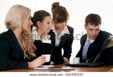 The company of four pretty businessman working at a table on a white background