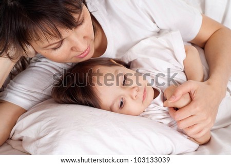 A beautiful Caucasian mummy with her daughter lying in bed