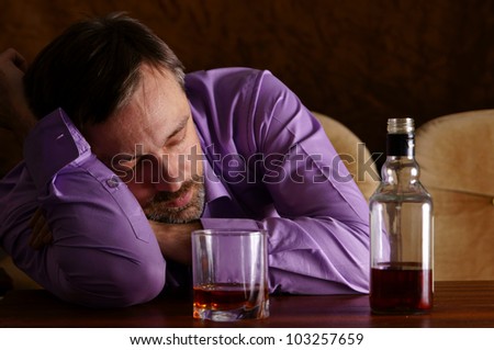 cute young man drinks whiskey at table