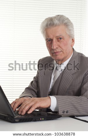mature man sitting at the laptop on a light background