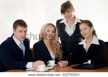 The company of four joy caucasian businessman working at a table on a white background