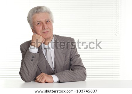 older businessman sitting on a white