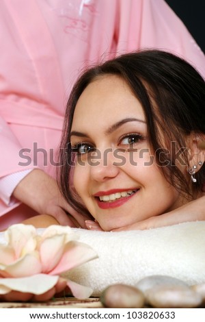 Happy Caucasian lady lying on a massage in the spa salon