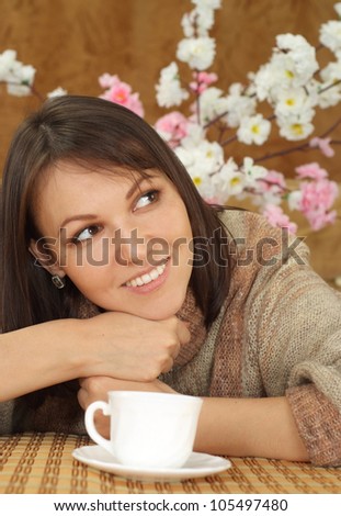 Beautiful luck charming Caucasian lady sitting on a sofa on a brown background