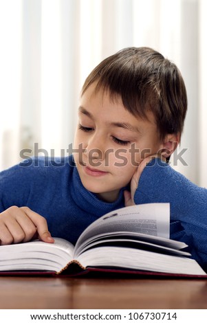Funny boy makes homework with a great pleasure at home