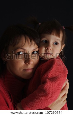 Happy sad Caucasian woman with a daughter on a dark background